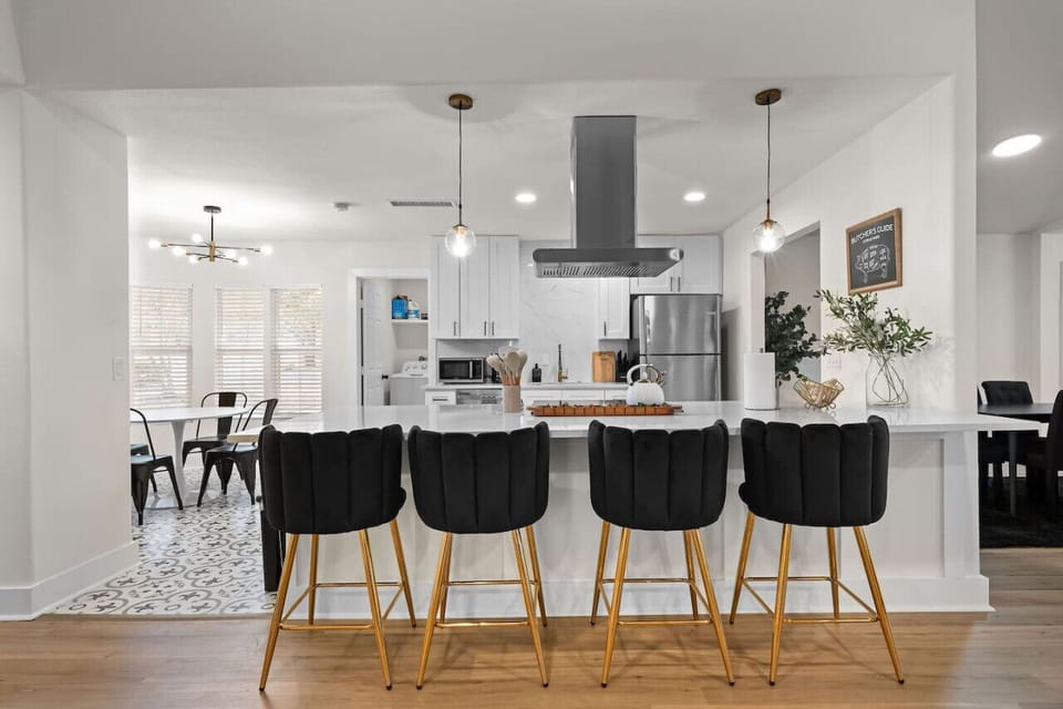 Experience open-concept living with this stylish kitchen and dining space! Featuring a sleek island with plush barstool seating, modern pendant lighting, and high-end stainless steel appliances—perfect for entertaining and creating unforgettable memories.