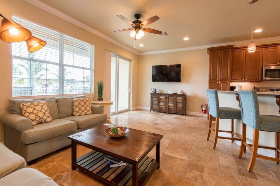 Bright living area with comfortable seating and a wall-mounted television.