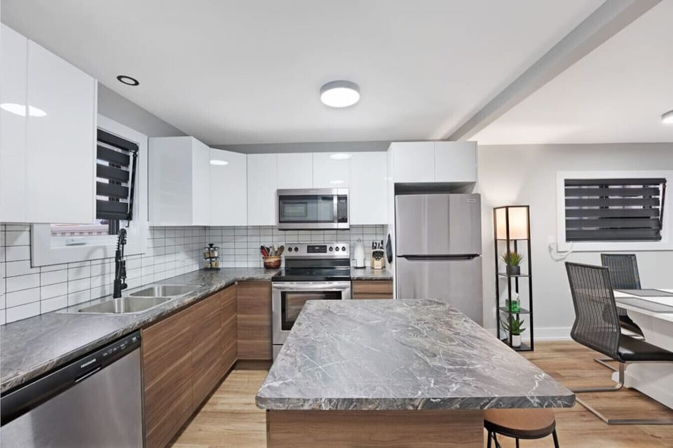 Experience luxury cooking in this modern kitchen island featuring a combined eating area, workstation, & food prep space. Sleek finishes & ample countertop space create a visually stunning environment. Host guests or whip up delicious meals in this u