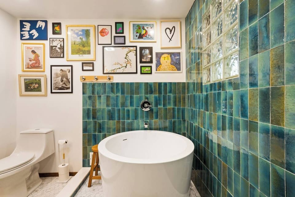 Accidentally Wes Anderson shot of the Main Bathroom - Custom Blue Tile, Japanese Soaking Tub, Gallery Art Wall
