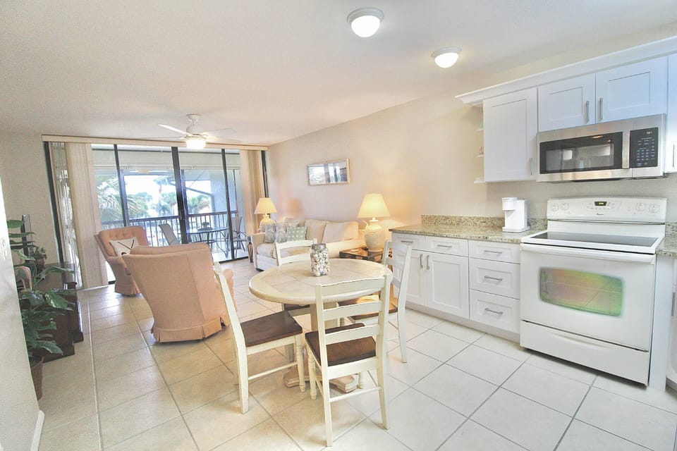 Welcome inside the main room of the Beachside Golf Villa! The kitchen & dining area lead into the sitting area and balcony.
