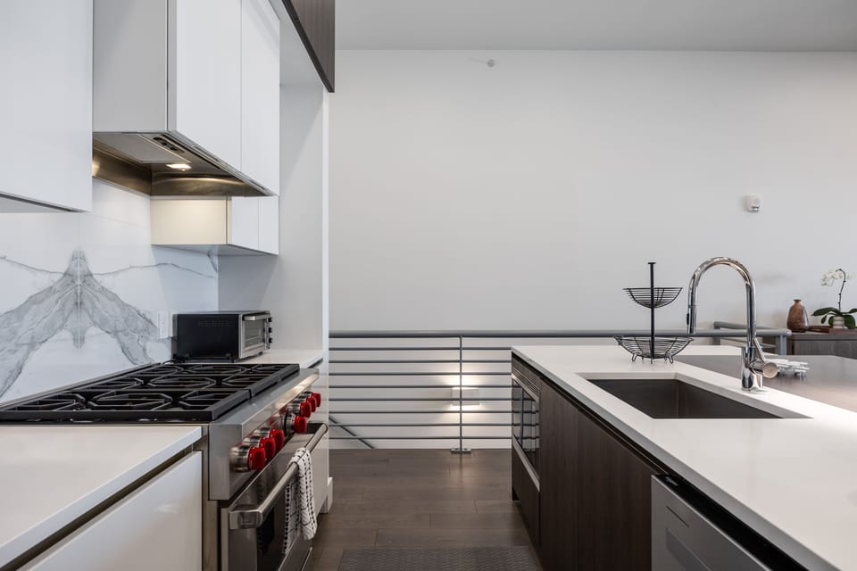 - Contemporary kitchen with large island and stainless appliances  
- Six burner gas range, deep sink, and sleek cabinetry design  
- Bright cooking space with clean countertops and mountain views