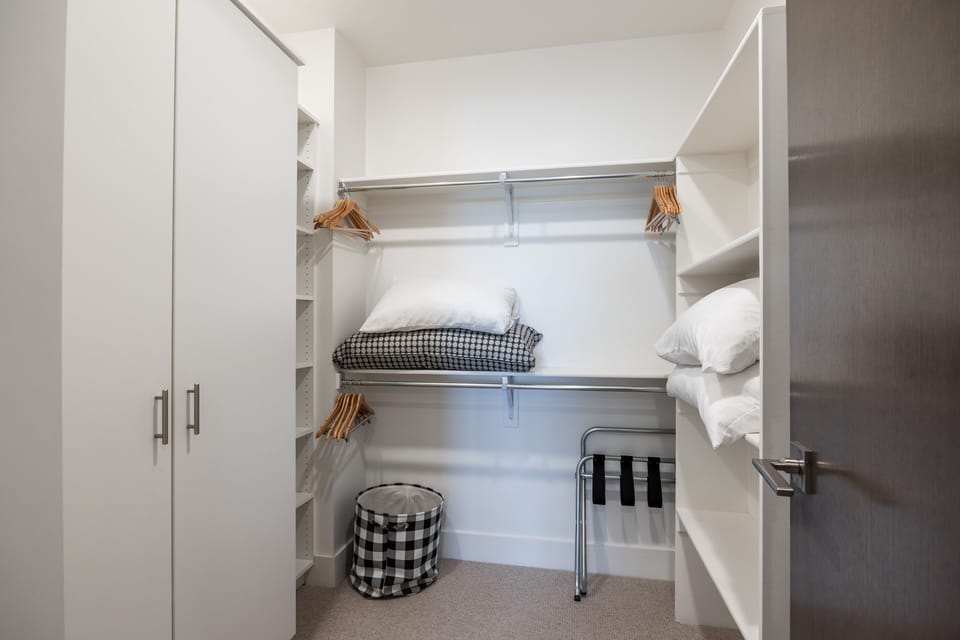 - Spacious walk-in closet with built-in shelves and extra storage  
- Organized layout with hangers, linens, and open shelving  
- Convenient space for unpacking and settling during your stay