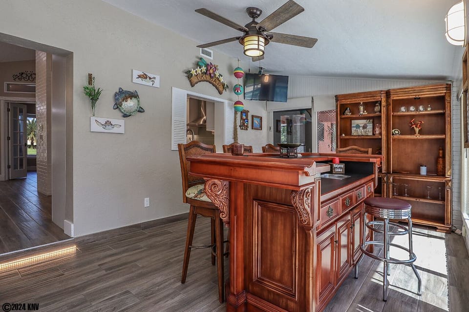 The Sun Room is an open, air-conditioned space that features an antique bar, a separate dining area and view of the pool.