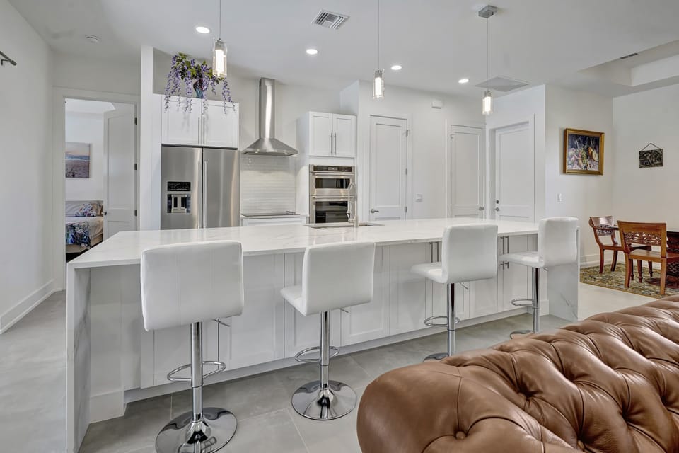 The kitchen features a full stainless steel set of appliances and quartz counter tops