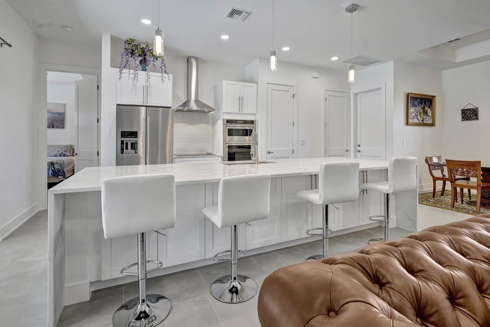 The kitchen features a full stainless steel set of appliances and quartz counter tops