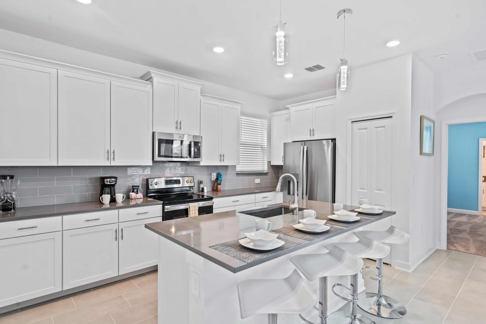 Represent Kitchen of the Apartment in Kissimmee Florida - Full equipped kitchen - Modern kitchen with sleek, stainless steel appliances - Breakfast bar - Integrated appliances for a seamless and stylish appearance - High chairs