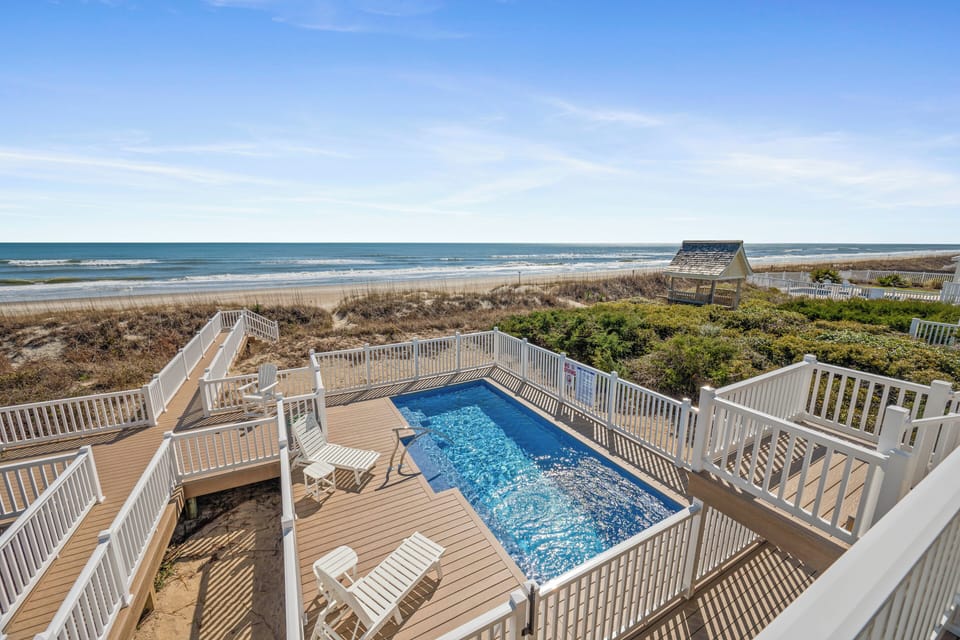 Spacious beachfront deck with private pool, lounge chairs, and stunning ocean views just steps from the sand.