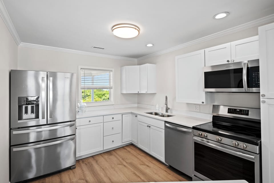Step into your bright, modern kitchen, fully equipped with stainless steel appliances, sleek white cabinetry, and everything you need to prepare your favorite meals during your stay.
