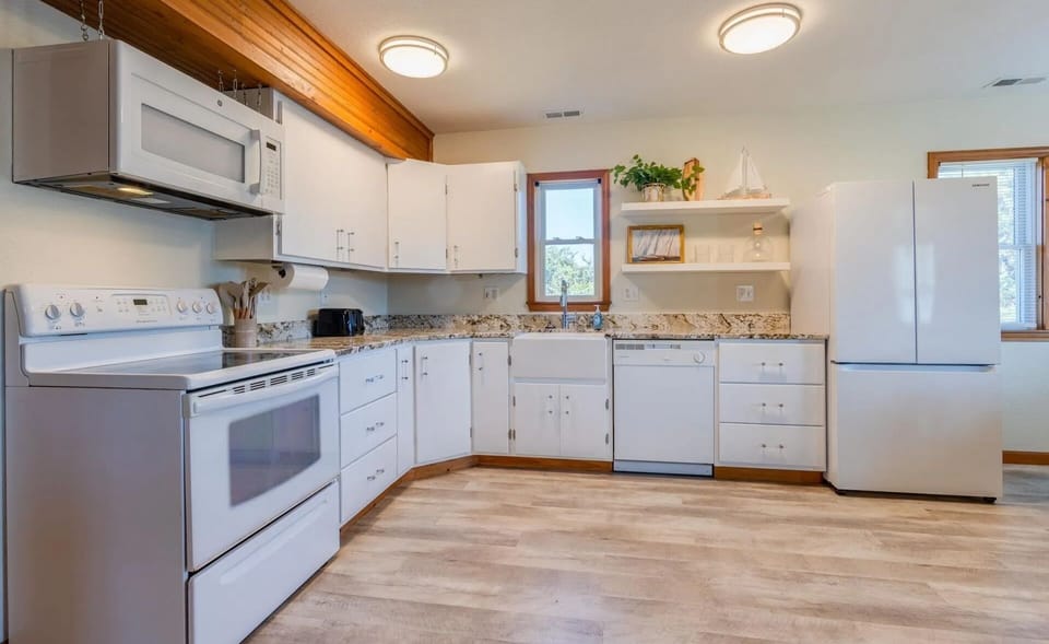 A coastal farmhouse kitchen stocked with dishes, small/large appliances – everything you need to feel at home.