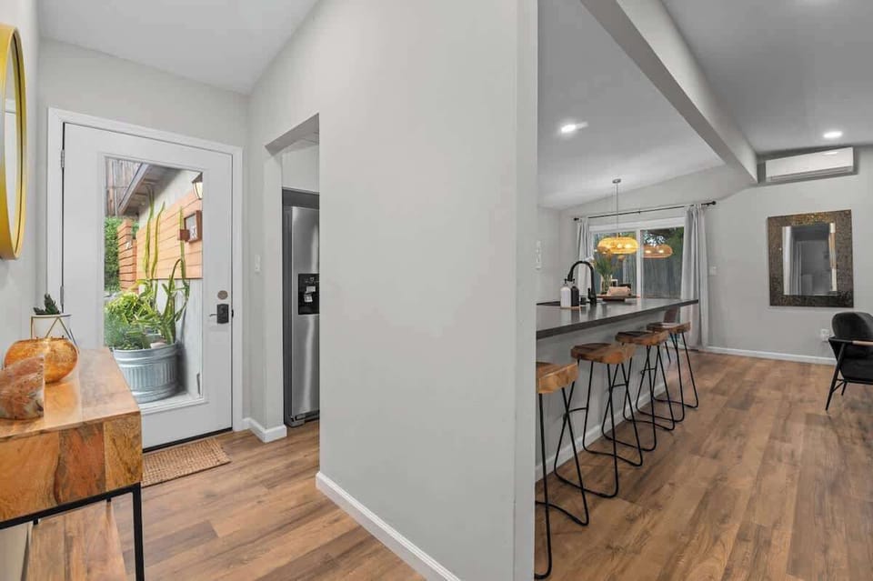 Chic and modern retreat with an open kitchen, stylish bar seating, and warm wood floors. Enjoy a bright, inviting space with elegant décor, perfect for relaxing, dining, or entertaining in comfort!