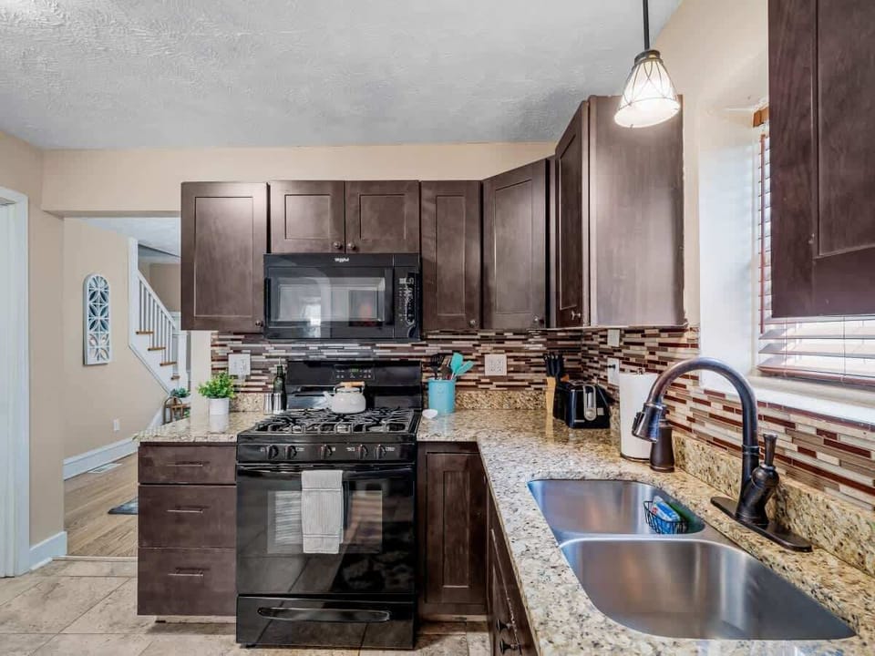 Modern kitchen  with granite countertops, stylish backsplash, and full-size appliances. Perfect for cooking up your favorite meals or enjoying morning coffee ☕.