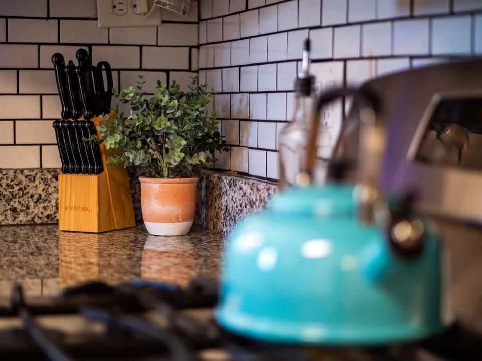 Bright, modern kitchen with crisp white cabinets, granite countertops, and subway tile backsplash. Stainless appliances and patterned wood-look floors flow seamlessly into the adjacent dining room for effortless entertaining! ️✨