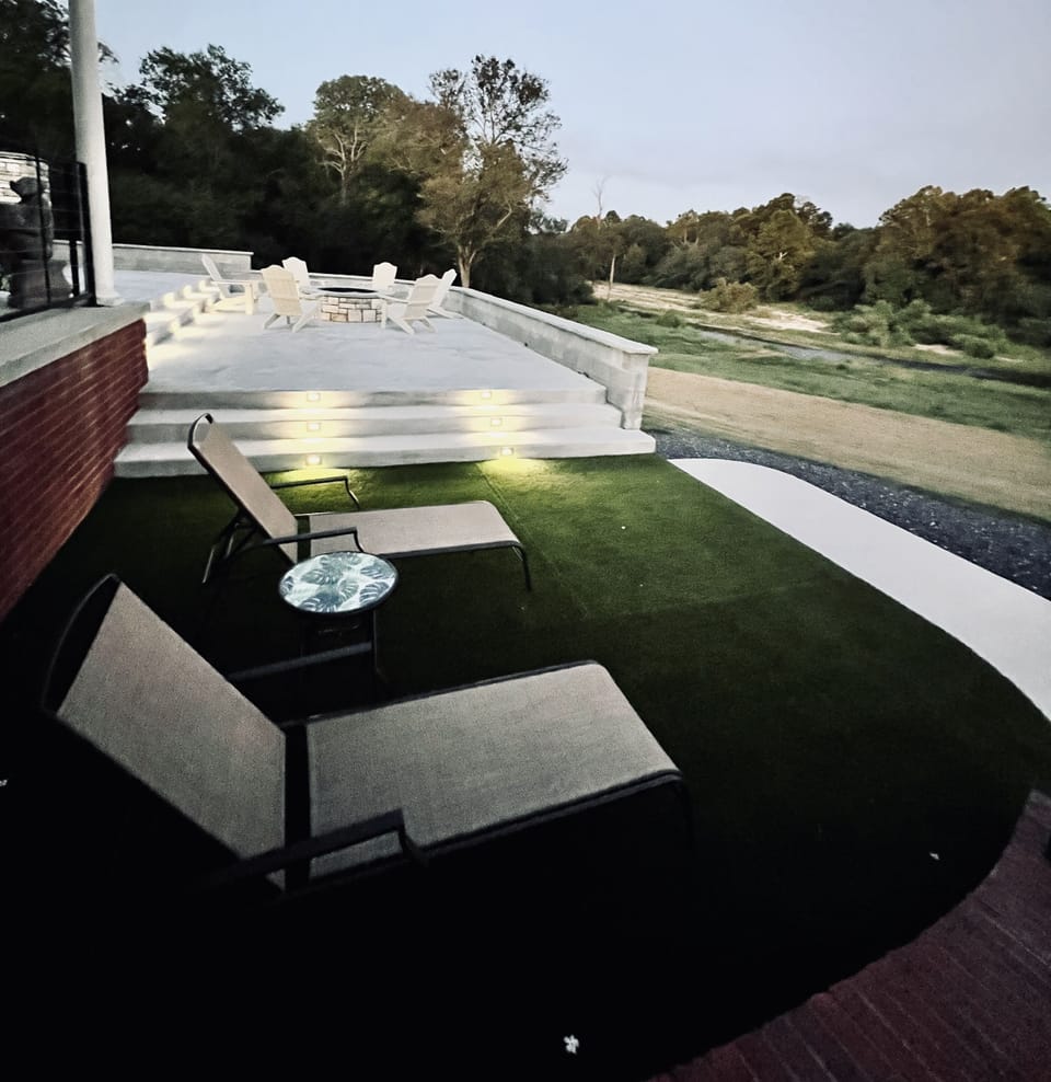 Outdoor living area with lounge area, table & chairs, and a firepit