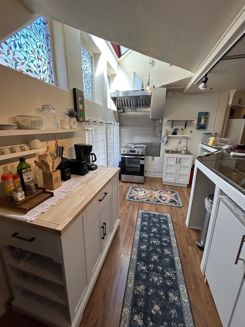 Full size range and farm sink with plenty of counter top space.  Commercial hood
