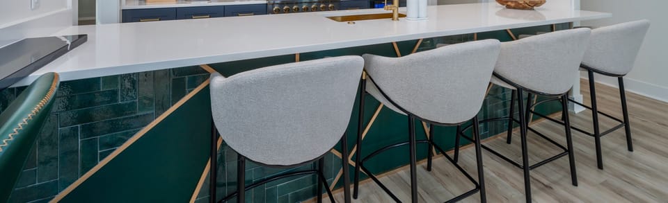 The Kitchen And Dining Area Showcases An Elegant Bar With Emerald Backsplash Tiles And Gold Accents, Emphasizing A Modern And Sophisticated Space.