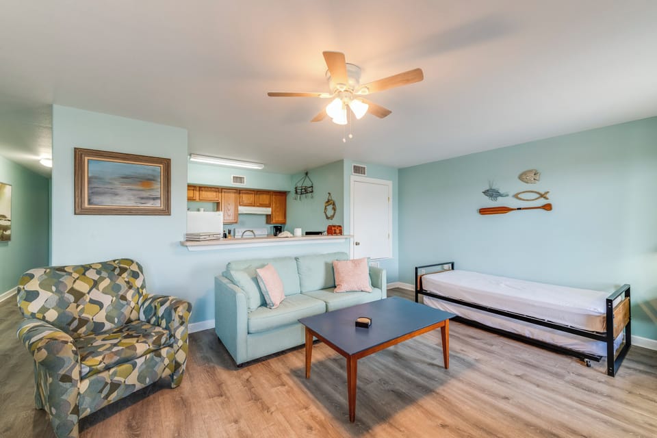 Bright, beachy living room with cozy seating, coastal decor, and a pull-out trundle bed—relax and unwind in style!