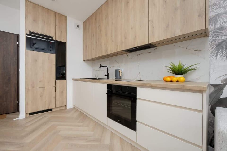 A well-equipped kitchen with modern appliances and wooden cabinetry. Clean lines and bright lighting complete the look.