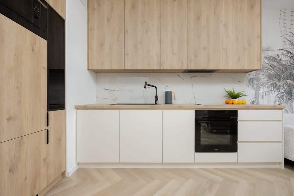 A sleek kitchen with wooden cabinets and a black oven. The compact layout is perfect for efficient cooking.