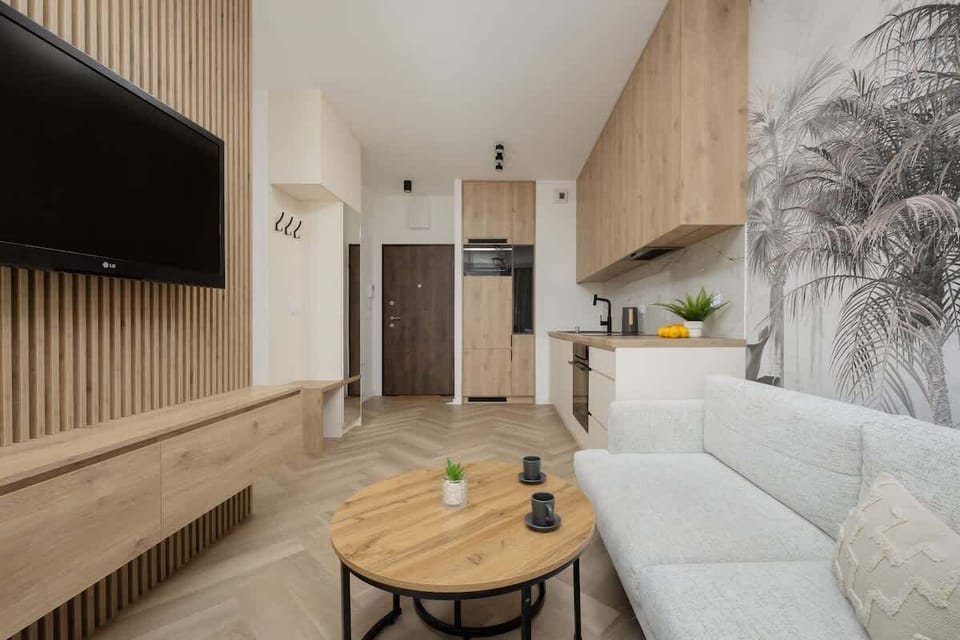 A bright living room with modern furnishings and nature-themed wall art. The space feels both elegant and homey.