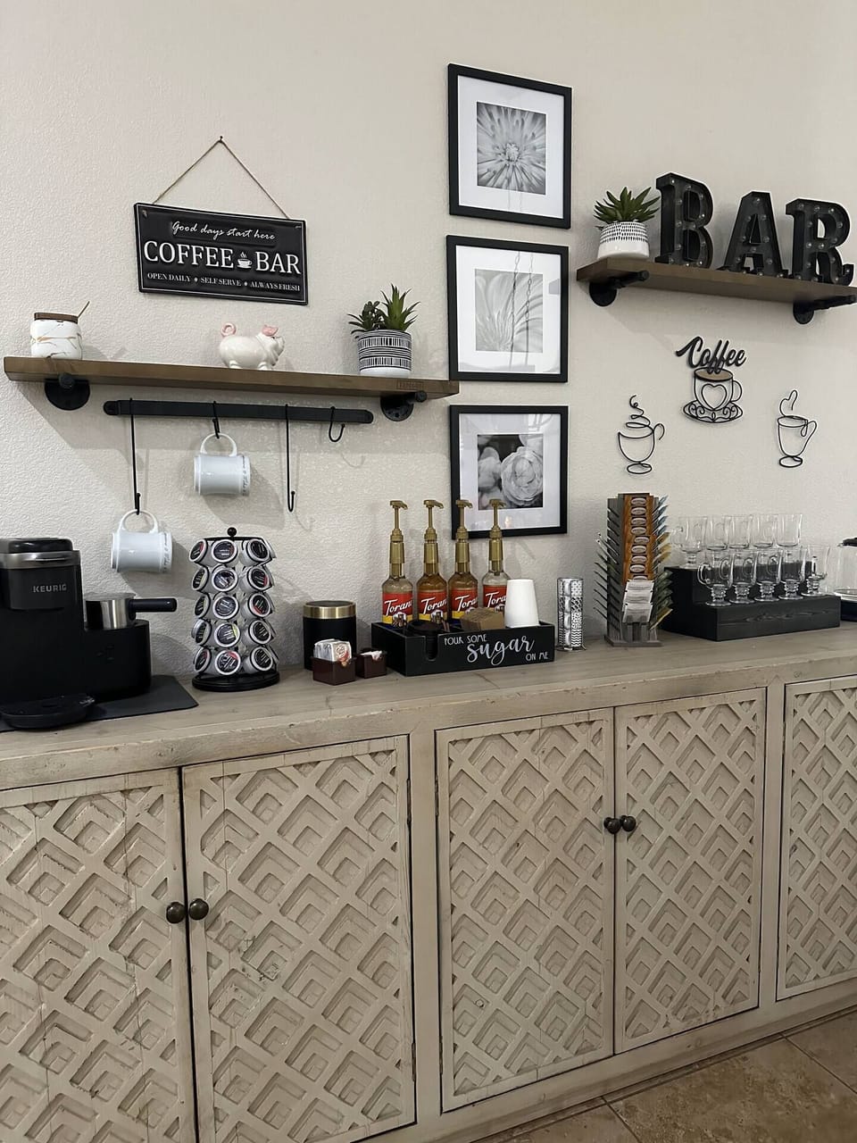 Full coffee and tea bar with Keurig latte maker, flavorings, and electric tea kettle.