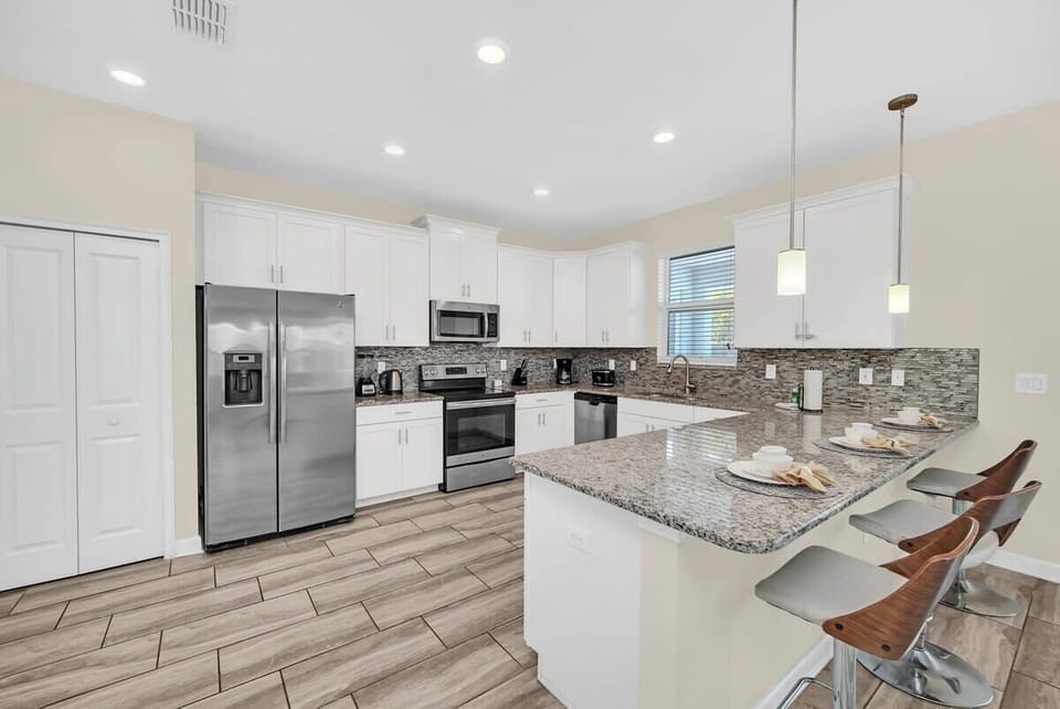 Cook with ease in the fully equipped open-concept kitchen featuring modern stainless steel appliances, generous counter space, and a layout perfect for gathering with family and friends.