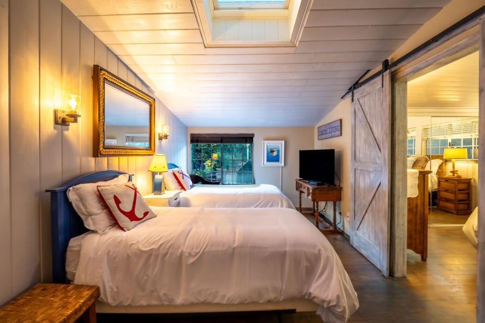 Sliding door leads to another bedroom with a Queen bed.