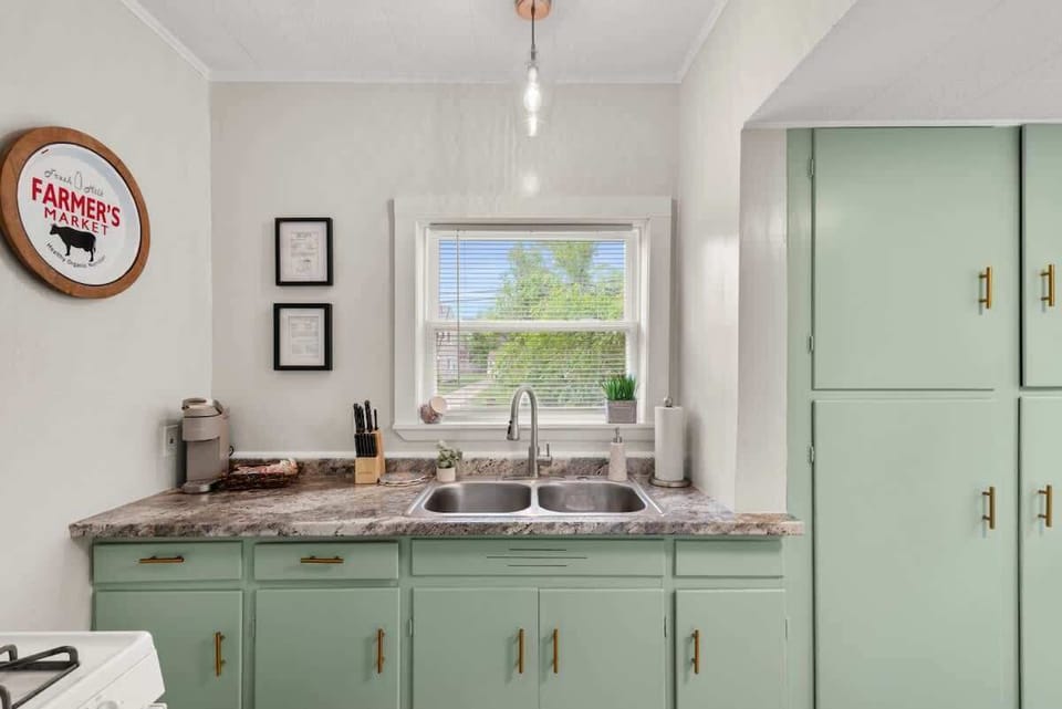 Charming kitchen sink area w/ mint cabinets, stone counters & window views while you prep meals