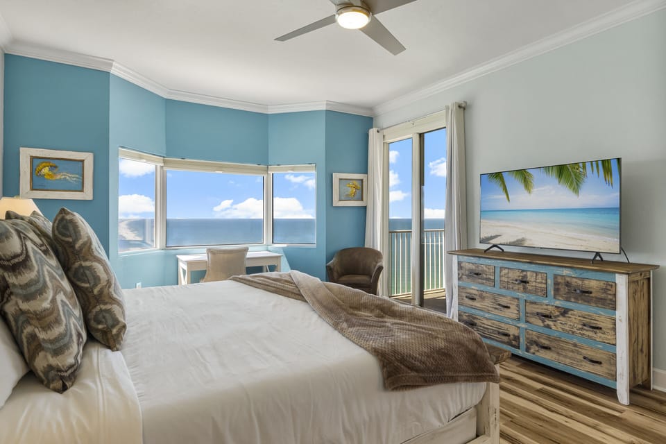 King-size master bed w/ private ensuite bath, workspace, & direct balcony access