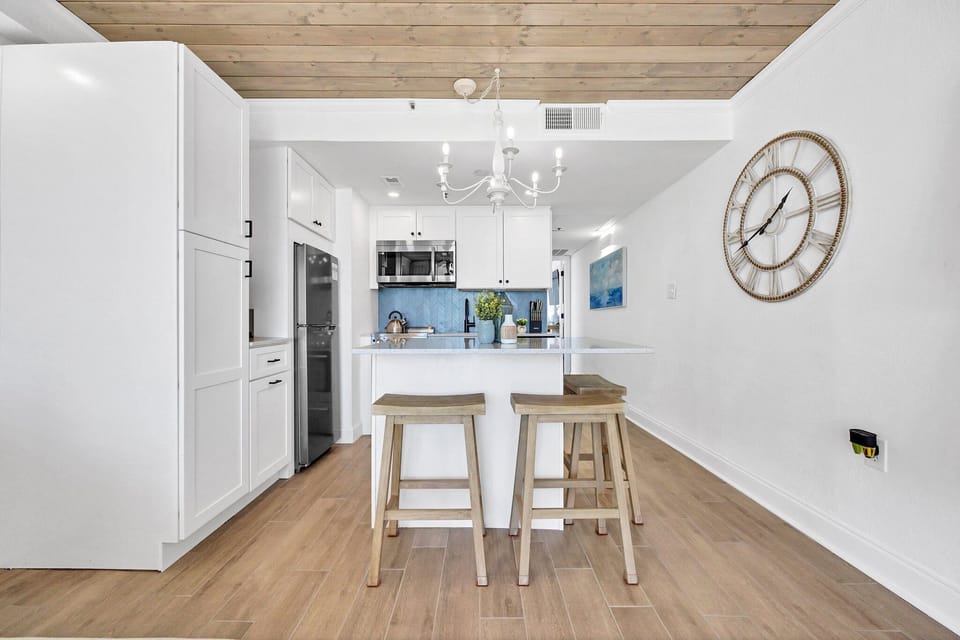 Kitchen with island, fridge, electric range, microwave and dishwasher.  
