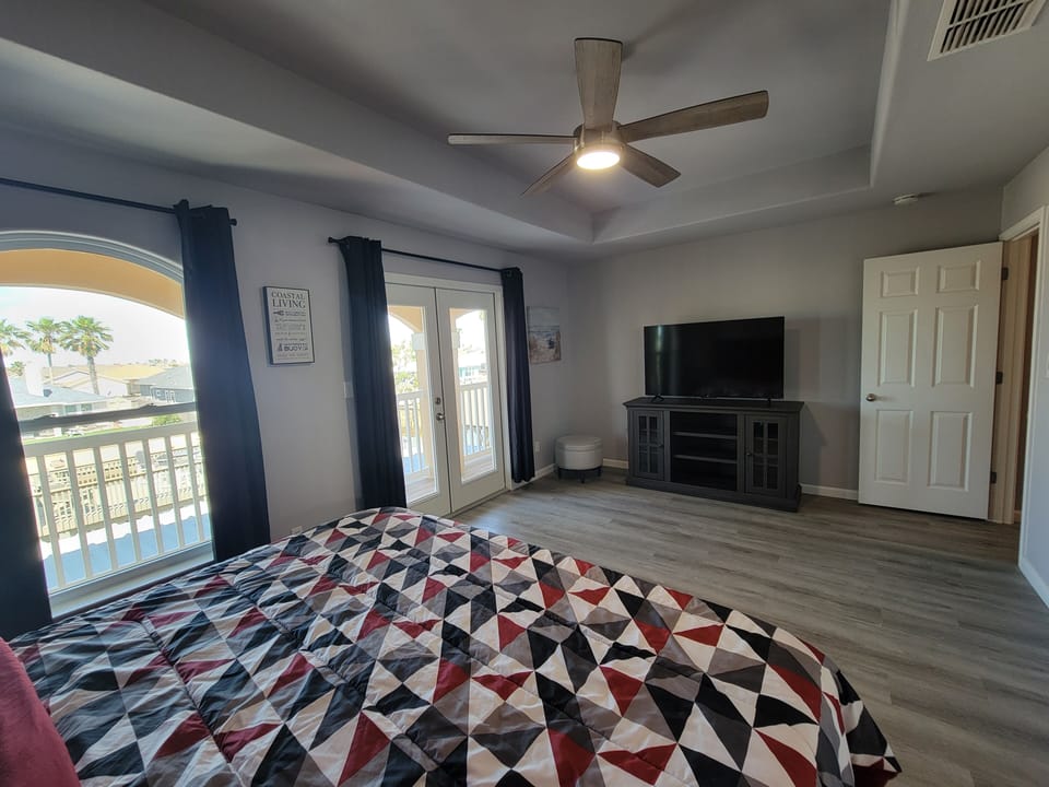 Primary room with large TV and view of backyard.