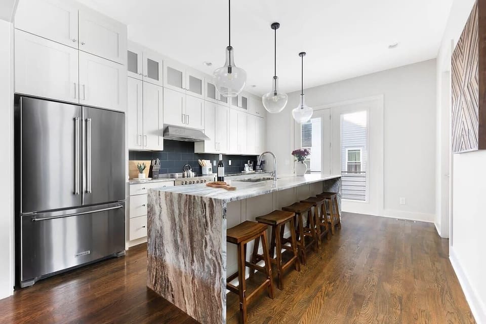 Clean and Spacious Kitchen with Sleek Countertops and Additional Seating