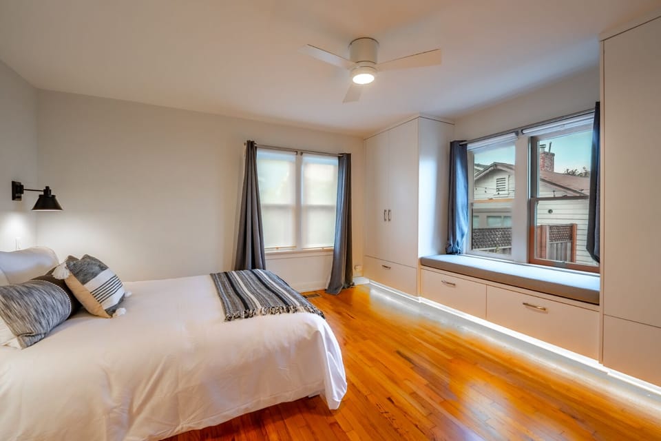 Wake up to natural light and serene views in this spacious primary bedroom with expansive windows.