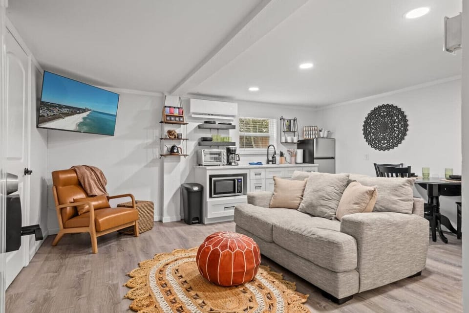 Explore the harmonious blend of our efficient kitchenette, cozy boho living room, and inviting dining area, all seamlessly connected and complemented by a TV for added entertainment and comfort.