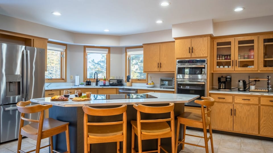 The kitchen features sleek stainless steel appliances and is fully stocked with everything you need for cooking.