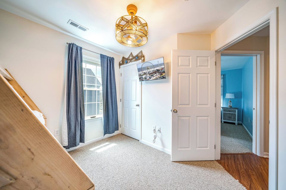 Charming bunk room with mounted TV and whimsical lighting