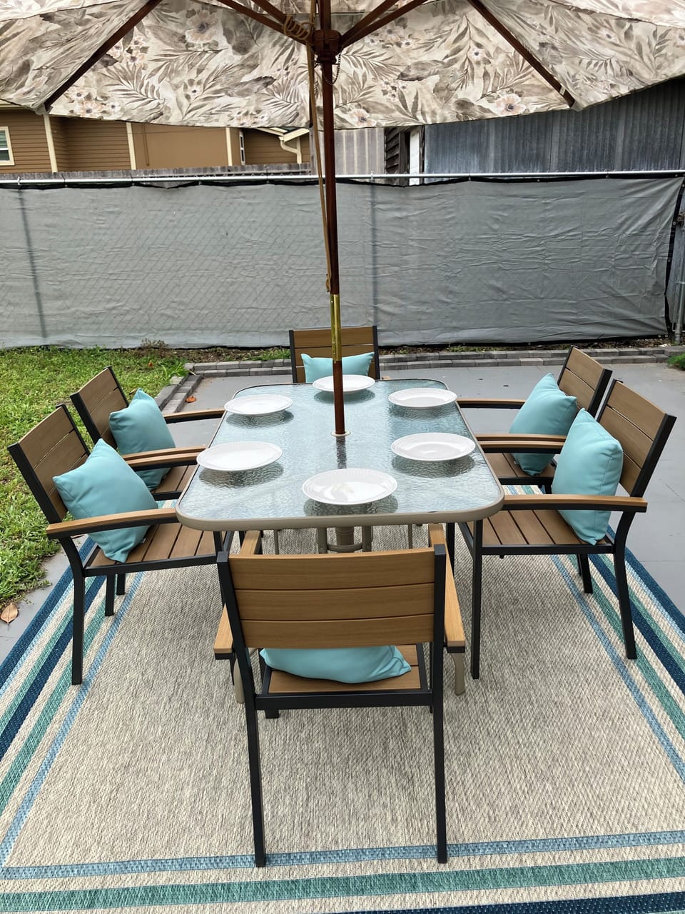 fenced back yard with grass and patio