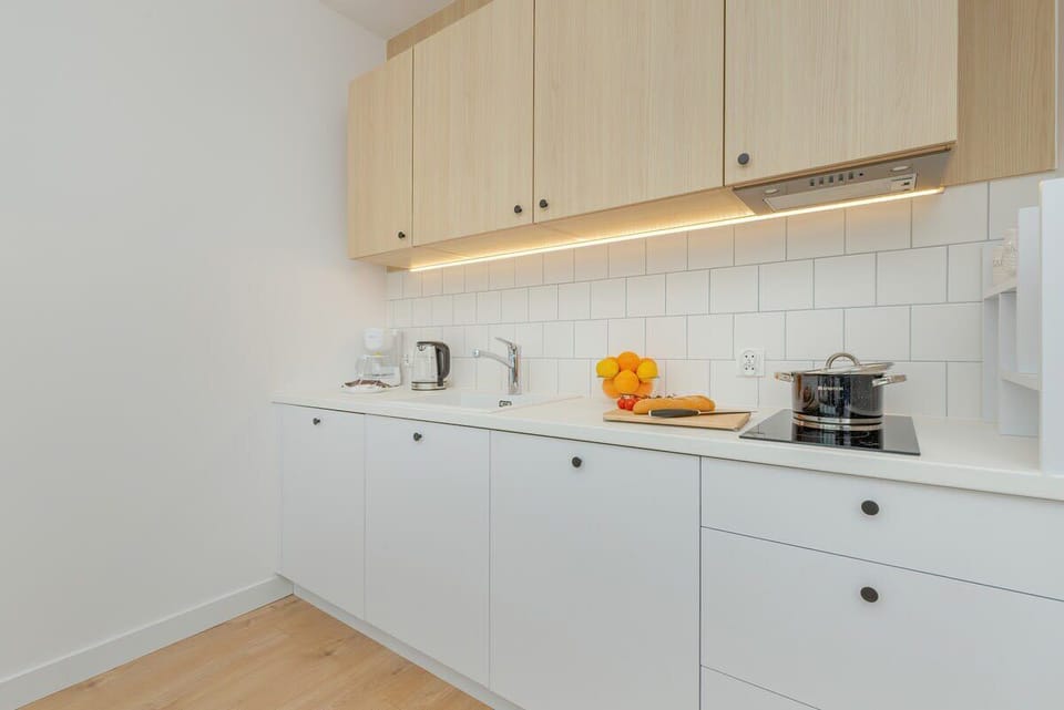 This bright and functional kitchen, with its harmonious combination of white and natural wood, exudes freshness and encourages culinary experimentation.