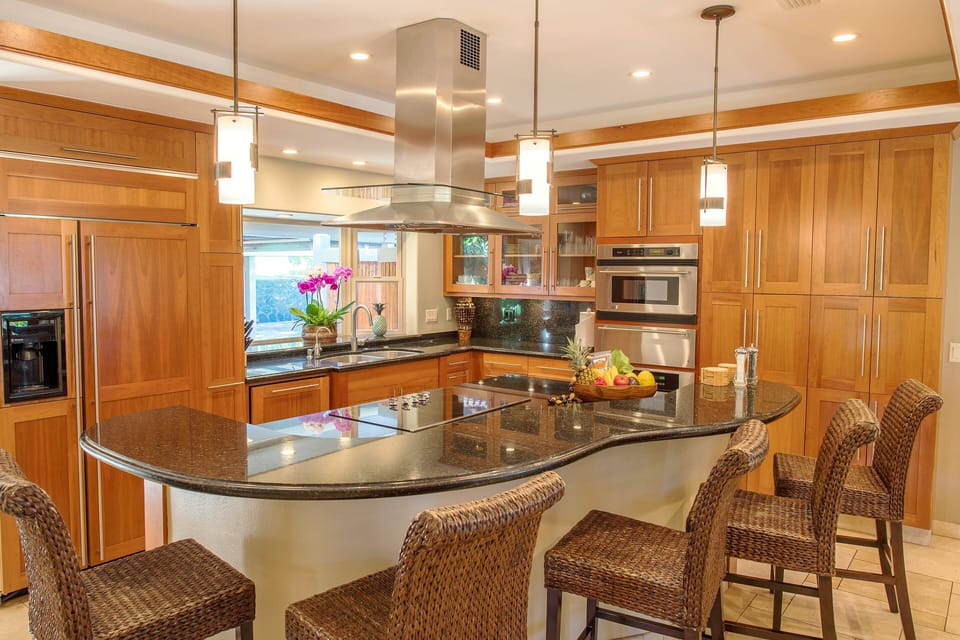 Savor the convenience of a fully-equipped gourmet kitchen featuring granite countertops, modern appliances, and island seating for social gatherings or family meals.
