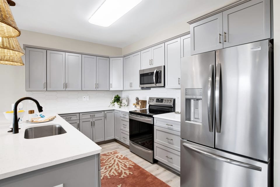 A kitchen space that marries the luster of stainless steel with the coziness of woven lighting, making every meal an experience