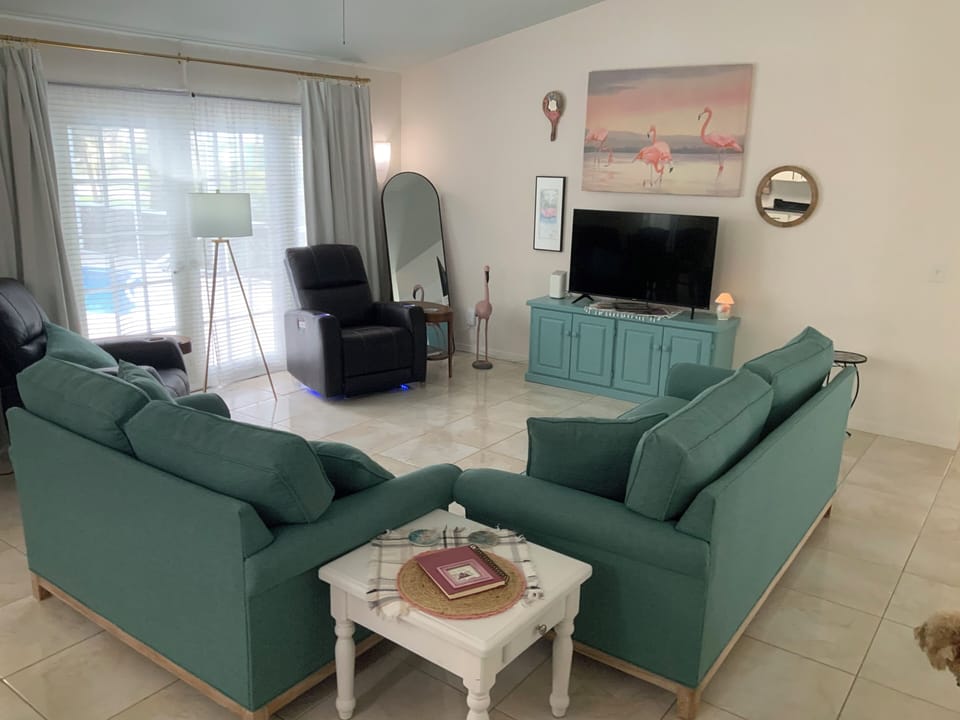 Livingroom open to kitchen and entry way.  View of the pool and lanai. Comfy