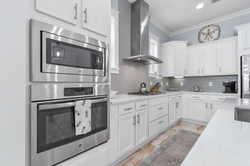 A bright and airy kitchen with double ovens, a gas range, and plenty of counter space for meal prep.