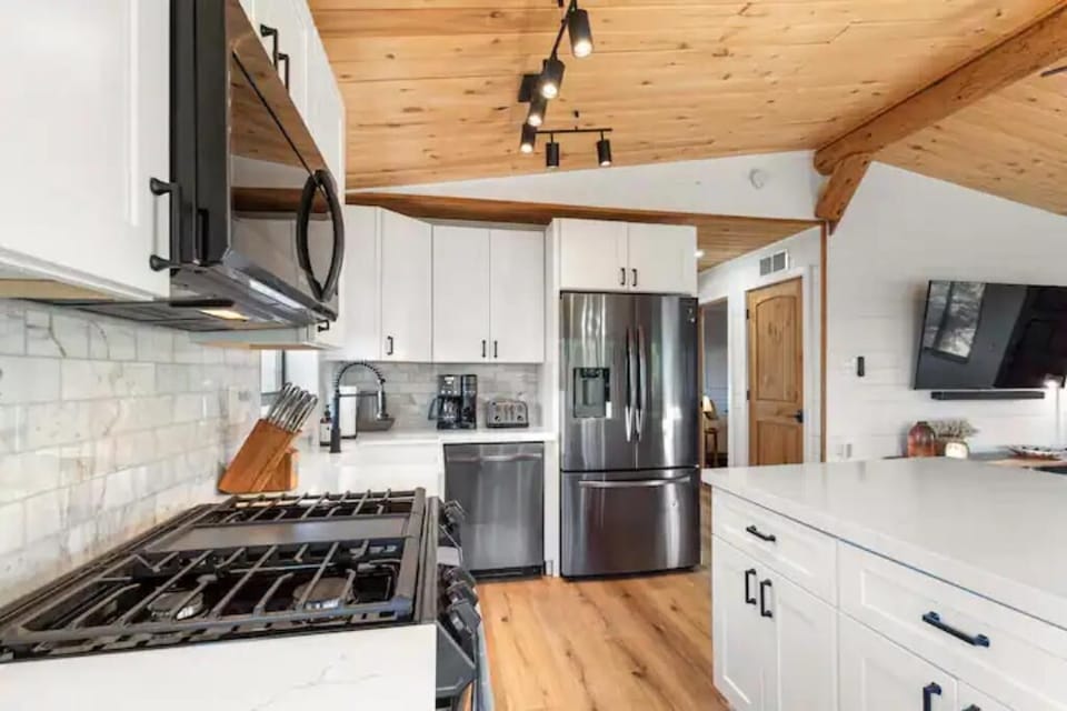Kitchen outfitted with gas range, microwave, dishwasher, and refridgerator.