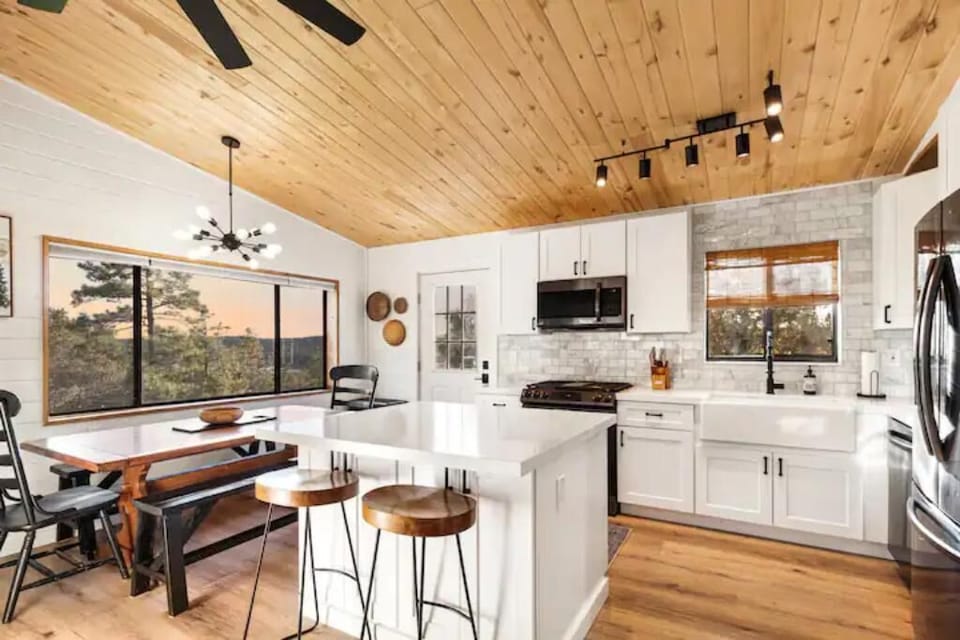 Dining table with benches and kitchen island with additional seating.