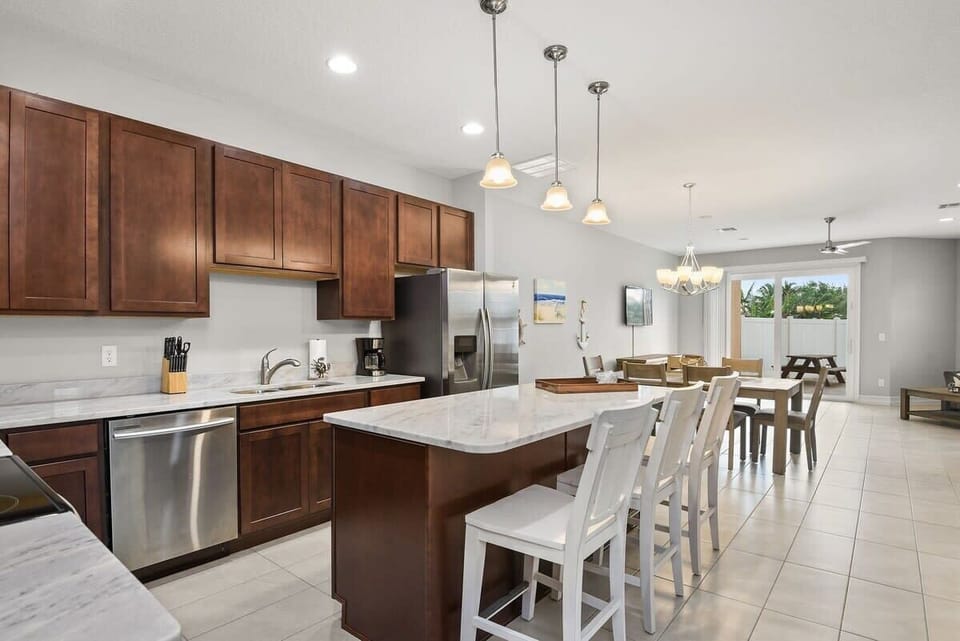 Modern kitchen with marble countertops and a spacious island for dining.