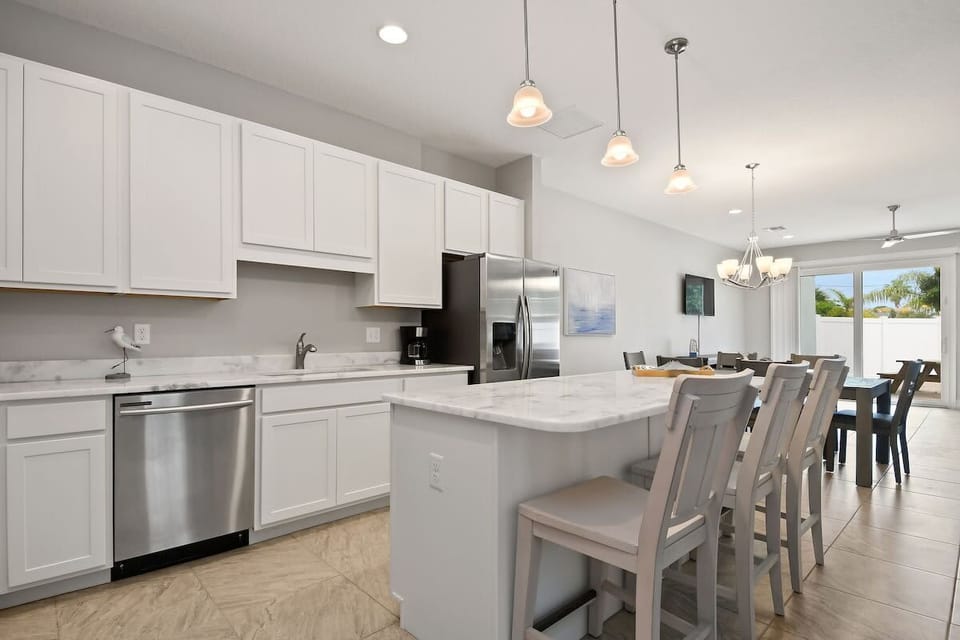 Modern kitchen with marble countertops and a breakfast bar opening to the dining area.