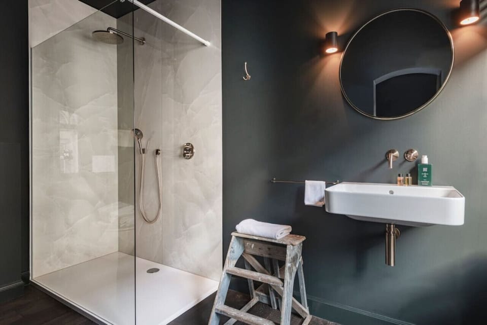 Bathroom scenery with sink, shower, toilet  and utilities.