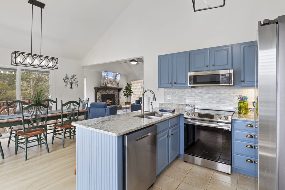 Cook up your favorite meals in this beautifully updated kitchen featuring granite countertops, stainless steel appliances, and charming blue cabinetry.