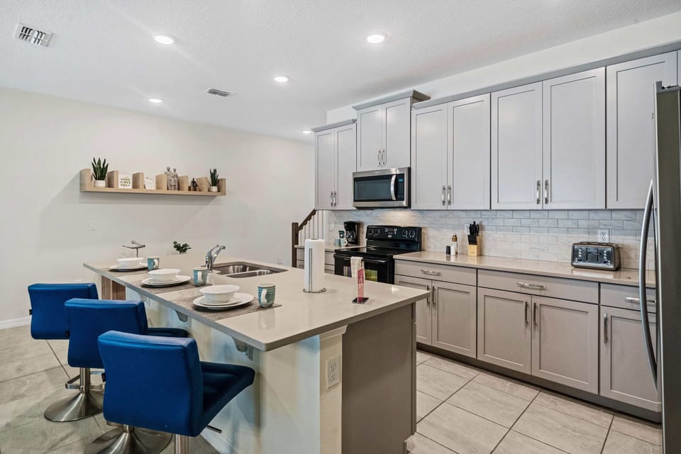 Sleek Kitchen of the Townhouse in Kissimmee Florida - Full equipped - Breakfast bar for additional workspace - High Chairs - Plenty of storage