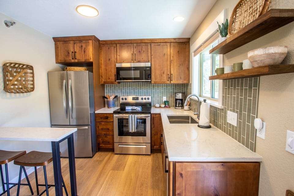 Kitchen with fridge, dishwasher, drip coffee maker, and beakfast bar.jpg